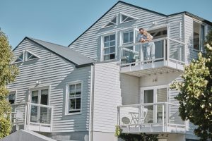 Real estate, house and couple relax on balcony of their dream home, happy, proud and laughing. Prop